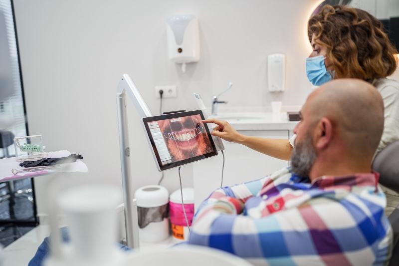 Dentist shows digital oral health images to patient in clinic in Livonia, MI