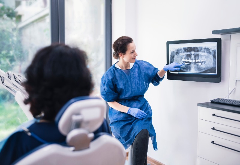 Dental provider explains oral health X‑rays to patient in Livonia, MI