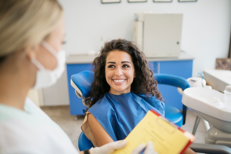 Patient discusses orthodontic evaluation with dental professional in Livonia, MI